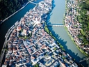 Luftaufnahme einer Flusslandschaft mit Stadt und Brücke.