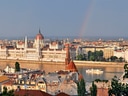 Parlamentsgebäude in Budapest mit Regenbogen im Hintergrund.