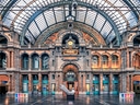 Innenansicht des Bahnhofsgebäudes mit grosser Uhr und architektonischen Details.