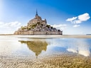 Le Mont-Saint-Michel bei Ebbe mit Spiegelung im Wasser.