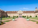 Historisches Schloss mit Garten und blauem Himmel.