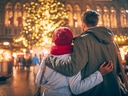 Paar umarmt sich vor beleuchtetem Weihnachtsbaum auf Markt.
