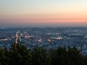 Stadtansicht bei Sonnenuntergang mit vielen Lichtern.