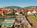 Blick auf städtische Landschaft mit Gewächshäusern und roten Dächern.