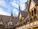 Historischer Innenhof mit bunten Dächern und gotischen Verzierungen.
