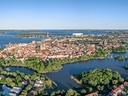 Luftaufnahme einer Altstadt auf einer Halbinsel am Wasser.