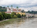 Stadtansicht mit Fluss und historischen Gebäuden.