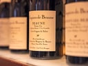 Nahaufnahme von Weinflaschen mit Etikett 'Hospices de Beaune'.