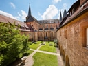 Klosterinnenhof mit Garten, historische Gebäude und Kirchtürme.
