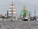 Segelboote auf dem Wasser vor Hafen und Stadtansicht.