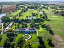 Luftaufnahme eines grossen Golfplatzes mit Wasserhindernissen und Gebäuden.