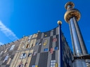 Kunstvoll gestaltetes Gebäude mit hohem Turm und blauem Himmel.