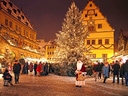 Weihnachtsmarkt mit grossem beleuchteten Baum und Menschenmenge.