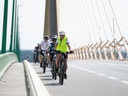Gruppe von Radfahrern auf einer Brücke.
