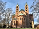 Alte Kirche mit zwei Türmen und blauem Himmel.