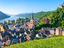 Malerisches Dorf am Rhein mit Kirche und Burgruine.