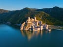 Luftaufnahme einer mittelalterlichen Burg am Flussufer.