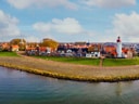 Küstenstadt mit Leuchtturm und Häusern am Ufer.
