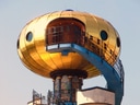 Buntes Gebäude mit goldener Kuppel und Aussentreppe.