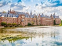 Historisches Gebäude am Wasser mit Wolken am Himmel.