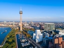 Luftaufnahme von Düsseldorf mit Rheinturm und modernen Gebäuden.