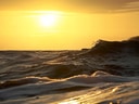 Sonnenuntergang über dem Meer mit Wellen.
