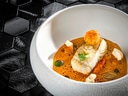 Gourmetgericht in weisser Schüssel mit Fisch.