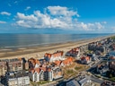 Luftaufnahme eines Küstenortes mit Strand und Gebäuden.