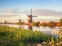 Windmühlen bei Sonnenuntergang am Fluss.