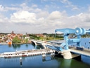 Klappbrücke mit Boot und Stadtansicht im Hintergrund.