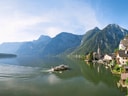 Panoramablick auf See mit Dorf und Bergen im Hintergrund.