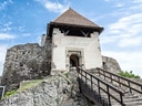 Mittelalterliche Burg auf Felsen mit Holztreppe.