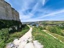 Pfad neben Festungsmauer mit Blick auf Fluss und Landschaft.