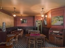 Gemütlicher, leerer Innenraum eines Restaurants mit Holzmöbeln und Hängelampen.
