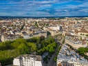 Luftaufnahme einer Stadt mit grünen Parkanlagen und Gebäuden.
