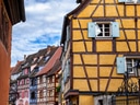 Bunte Fachwerkhäuser an einer Strasse unter blauem Himmel.