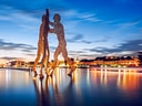 Molecule Man-Skulptur im Wasser bei Sonnenuntergang.