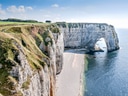 Kalkstein-Klippen von Étretat mit Felsbogen und Meer.