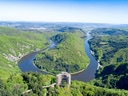 Luftaufnahme von Fluss und Wäldern in grüner Landschaft.