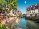 Malerischer Kanal mit historischen Gebäuden und Blumen.