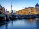 Abendliche Stadtansicht mit Brücke und Fluss.