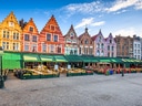 Stufenförmige Giebelhäuser in Brügge vor blauem Himmel.