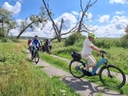 Radfahrer auf ländlichem Weg bei sonnigem Wetter.