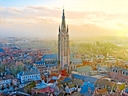 Luftaufnahme von Brügge mit Kirchturm bei Sonnenuntergang.