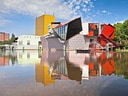 Bunte moderne Gebäude spiegeln sich in einem ruhigen Fluss.