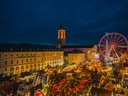 Nachtmarkt mit bunten Lichtern, Menschenmengen und einem grossen Riesenrad.