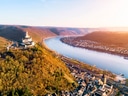 Luftaufnahme einer Burg am Flussufer im Herbst.