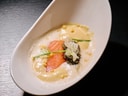 Elegantes Gericht mit Lachs und Schaum auf schwarzem Hintergrund.