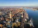 Luftaufnahme einer Stadt mit Fluss und Hafen voller Segelboote.