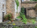 Steinhaus mit Pflanzen und Blumen im Innenhof.